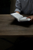 man reading from the pages of a Bible 