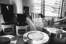 mugs and coffee pot on a counter by a sink in a camper 