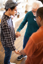 men holding hands in prayer 