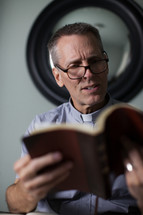 A minister preparing a sermon and reading a Bible