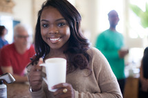 woman holding a coffee mug at a small group gathering 