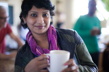 woman holding a coffee mug at a small group gathering 
