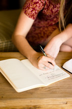 a woman writing notes in a journal 