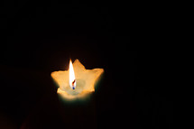 A single candle burning in the dark.