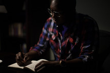 African-American man writing in a journal 