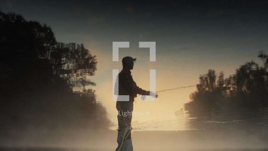 Young fly fisherman casting on a foggy river at sunrise