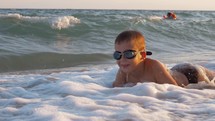 Child is excited with sea waves covering him