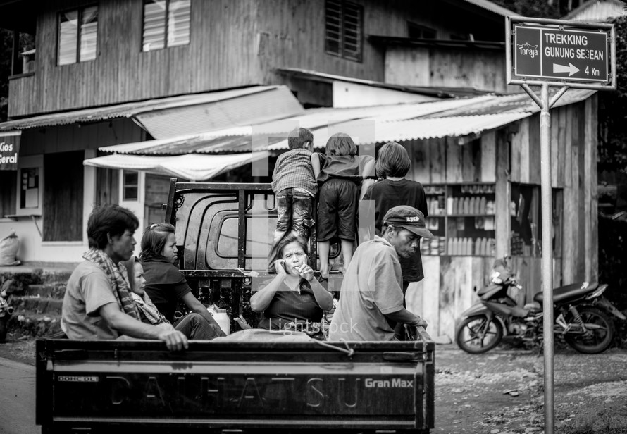 people riding in the back of a truck in Toraja
