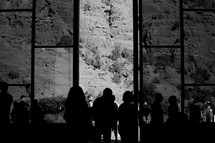 silhouettes outside a glass chapel in the desert mountains