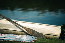 row boat next to a blanket in the grass