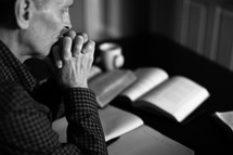A minister prays as he prepares a sermon.