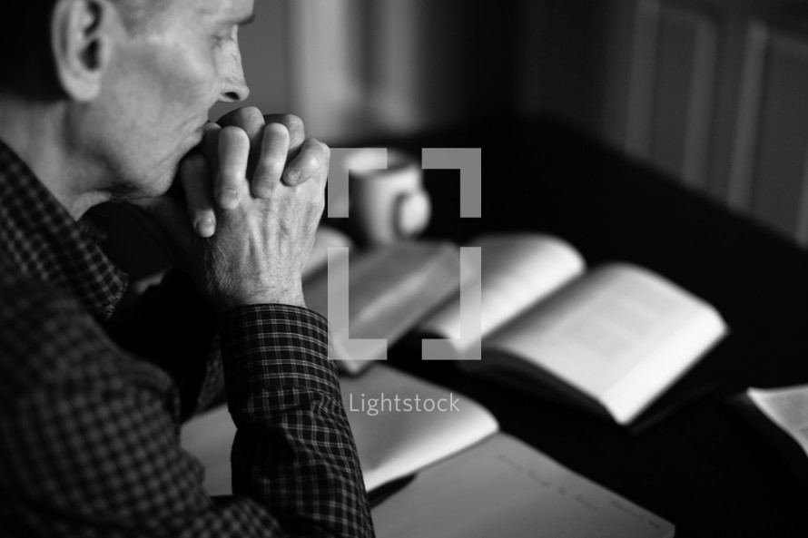 A minister prays as he prepares a sermon.