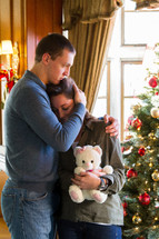 couple hugging in front of a Christmas tree, Christmas sadness 