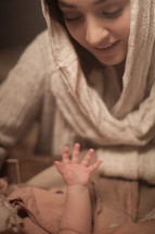 Baby Jesus reaching up to Mary.