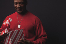 man opening a Christmas gift