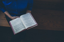 woman holding a hymnal 