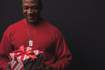 man opening a Christmas gift 