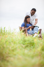 happy couple reading a Bible together outdoors 
