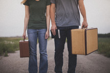man and woman carrying suitcases and holding a Bible