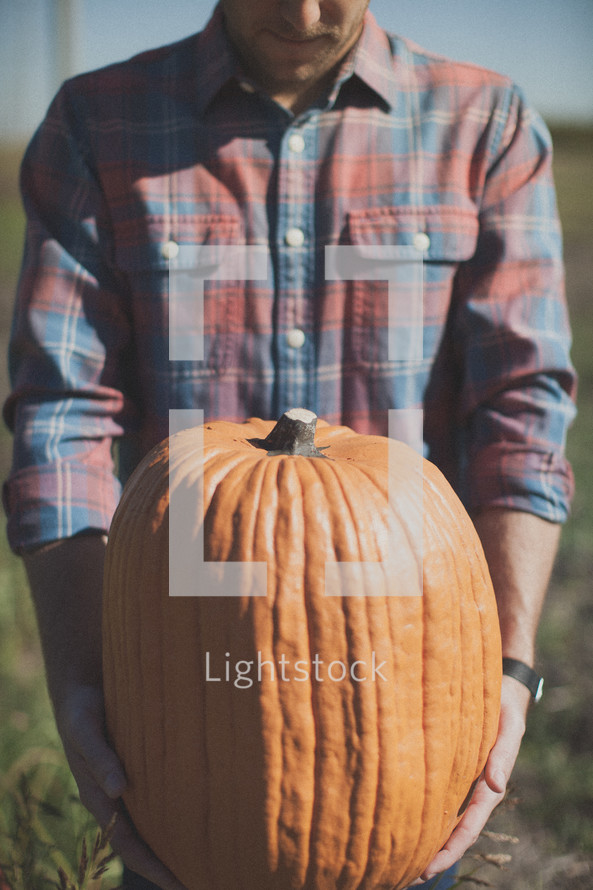 man holding a pumpkin 
