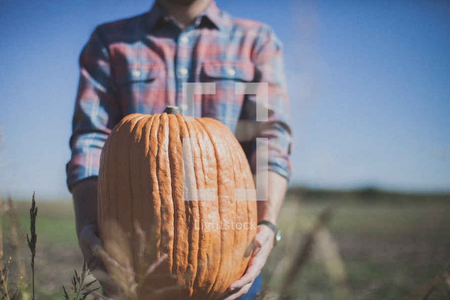 man holding a pumpkin 