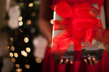 An African American woman holding a wrapped Christmas gift 