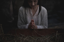 Mary praying over the manger