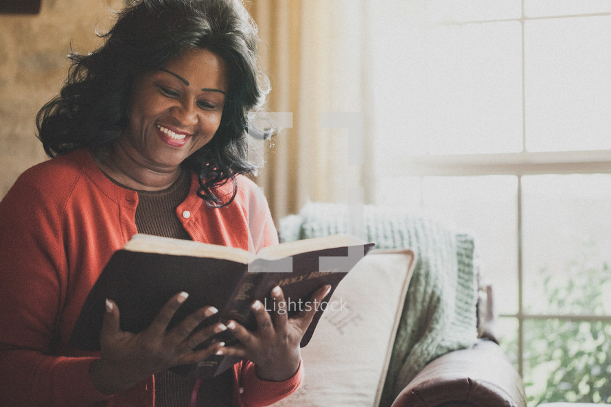 Joyful woman reading the Bible.