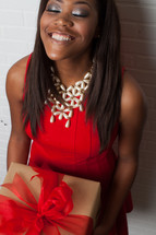 An african-american woman holding a wrapped gift