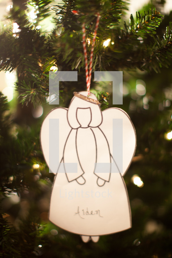 an angel ornament hanging on a Christmas tree 