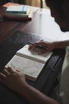 man reading a Bible at a desk