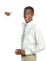 Young man standing by a white wall in dress clothes