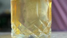 Slow motion of pouring whiskey into glass. 
