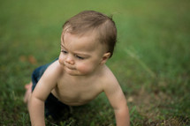 A baby crawling on grass