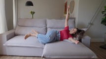Woman jumping on soft sofa 
