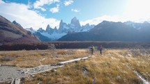 Young couple hiking, trekking in mountains with backpacks, enjoying their adventure - tourism concept at El Chantel Argentinean Patagonia
