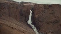 waterfall off of a brown cliff 