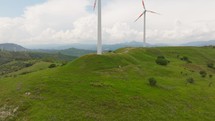 Wind Turbines on top of green hill 