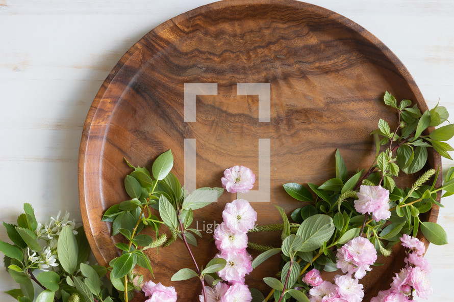 blossoms and teak tray and cross on white