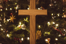 Wooden cross in front of a Christmas tree
