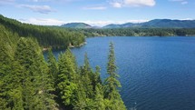Aerial view of a beautiful freshwater lake, a mountain range, and forest.
