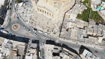 Bird's-eye view aerial 4k drone footage flying over the Mosta Rotunda Dome, a Roman Catholic church, and it's surrounding city of Malta.