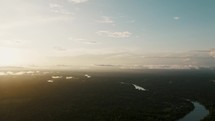 Aerial tilt down shot of beautiful sunrise at horizon lighting on Amazon River in Peru in the morning.

