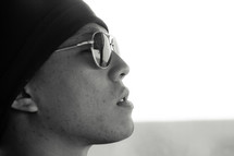 profile of a man in sunglasses and hoodie