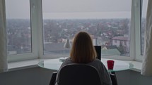 Woman sitting at a desk working on her computer with a scenic view