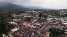 Aerial orbit shot of Our Lady of Carmen Church in Salento Town with Mountains in Background, Colombia