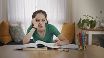 Frustrated teen girl trying and failing to prepare homework for school