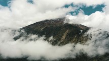 Beautiful White Clouds Enveloping Tungurahua Volcano Above Baños de Agua Santa In Ecuador. Aerial Shot	