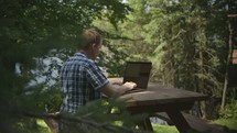 man working on a laptop outdoors 
