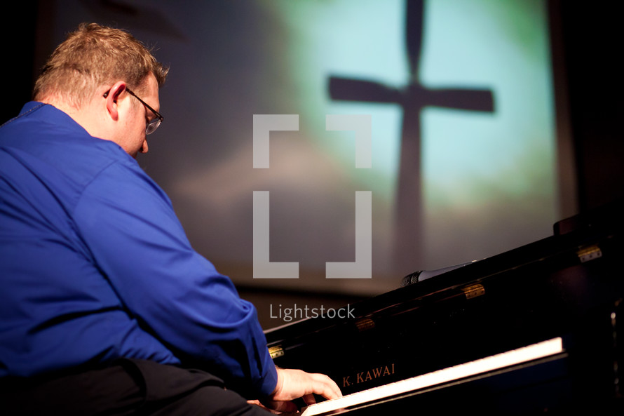 man playing a piano at a worship service